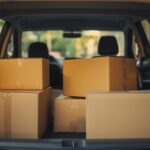 Caixas de papelão organizadas no porta-malas de um carro, representando transporte e entrega de mercadorias.