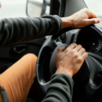 Motorista profissional conduzindo veículo com segurança durante trajeto corporativo.